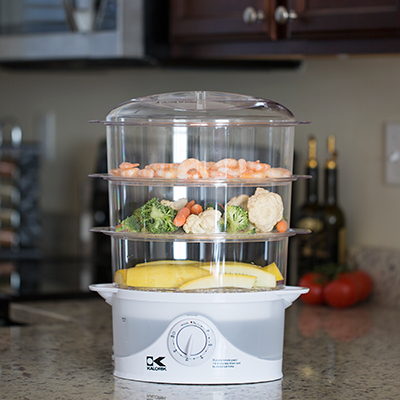 KALORIK<sup>&reg;</sup> 3-Tier Food Steamer - Create healthy meals  with this 3-tiered food steamer.  Steamer features 3 cooking tiers as well as a rice cooking tray for a total capacity of 9 quarts.  Food containers have convenient carry handles and stack inside each other for easy storage.  Also includes see-through water tank and 60 minute timer with auto-off function.