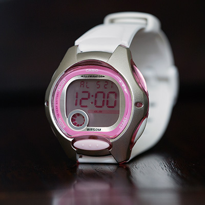 CASIO<sup>&reg;</sup> Women's Digital Watch - This digital women's watch has a white band with silver case and pretty pink dial. Features include an alarm, stopwatch, dual time, LED light and date display. Water resistant to 50 meters.